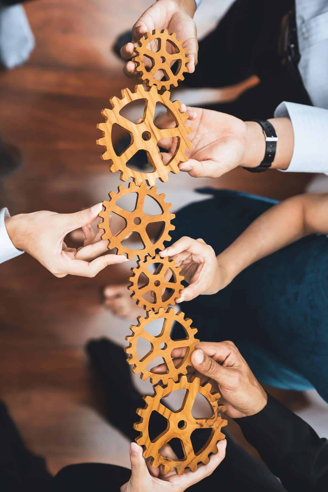 Office Worker Holding Cog Wheel As Unity And Teamwork In Workplace. Concord